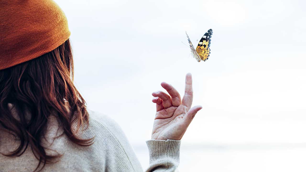 Frau lässt einen Schmetterling fliegen
