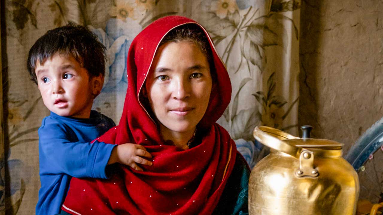 Kabul, Afghanistan: Hazara-Frau mit Kind kocht Tee