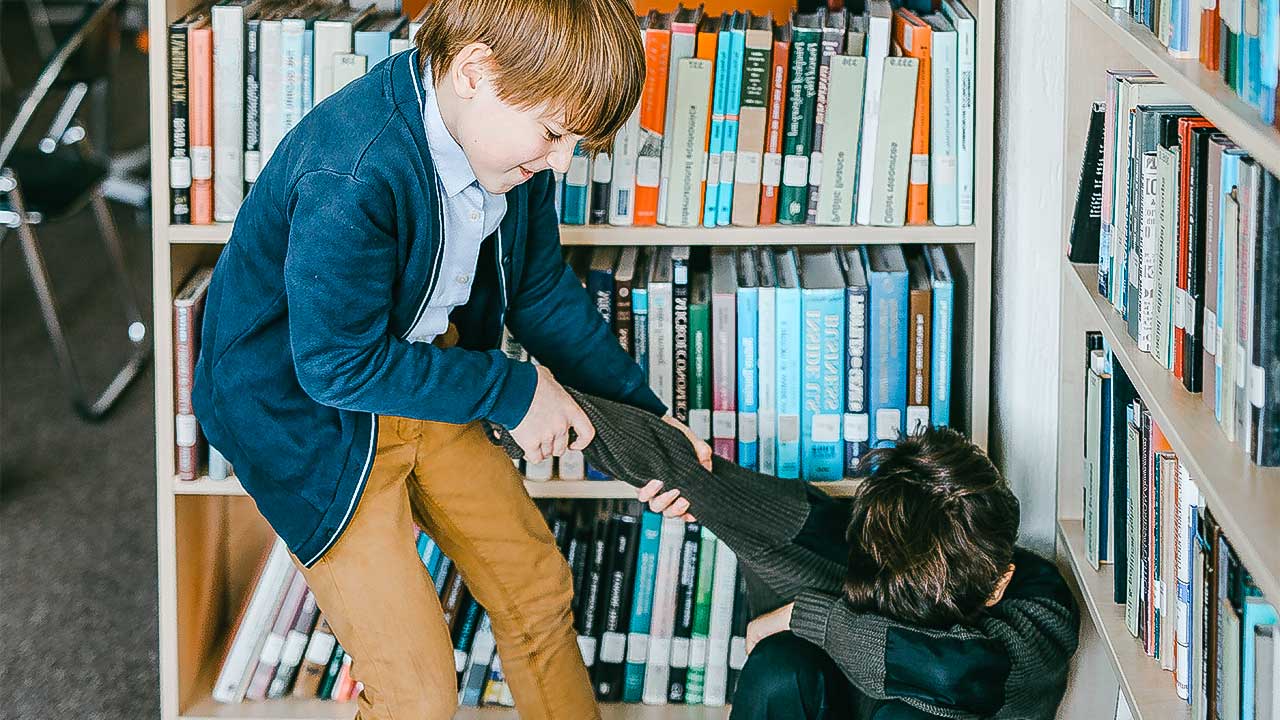 In einer Bibliothek mobbt eine Junge einen anderen