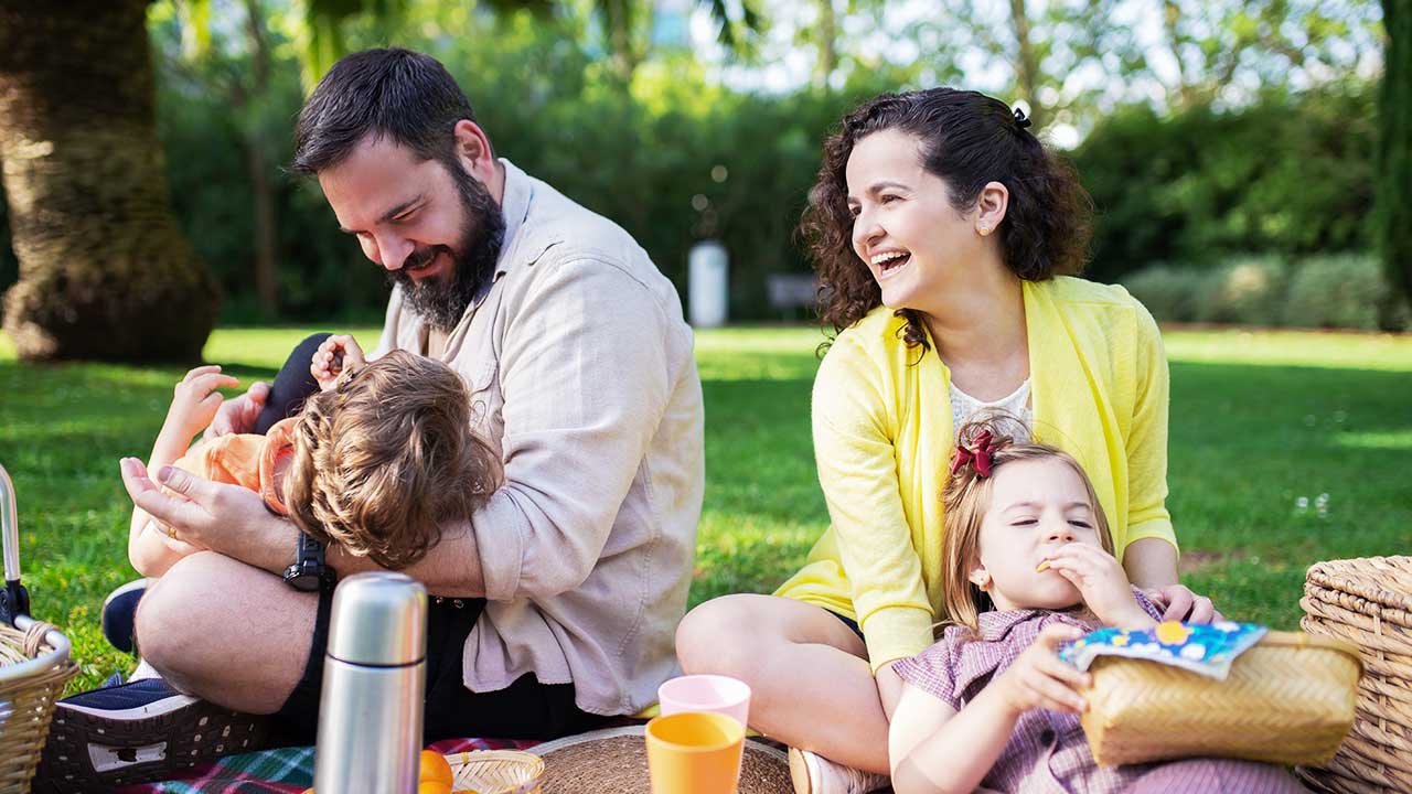 Familie mit zwei Eltern und zwei Kindern beim Picknick