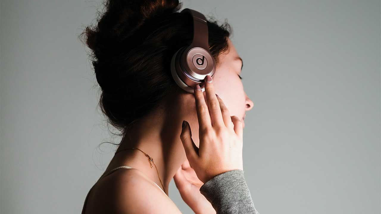 Profilansicht einer jungen Frau, die konzentriert Musik hört