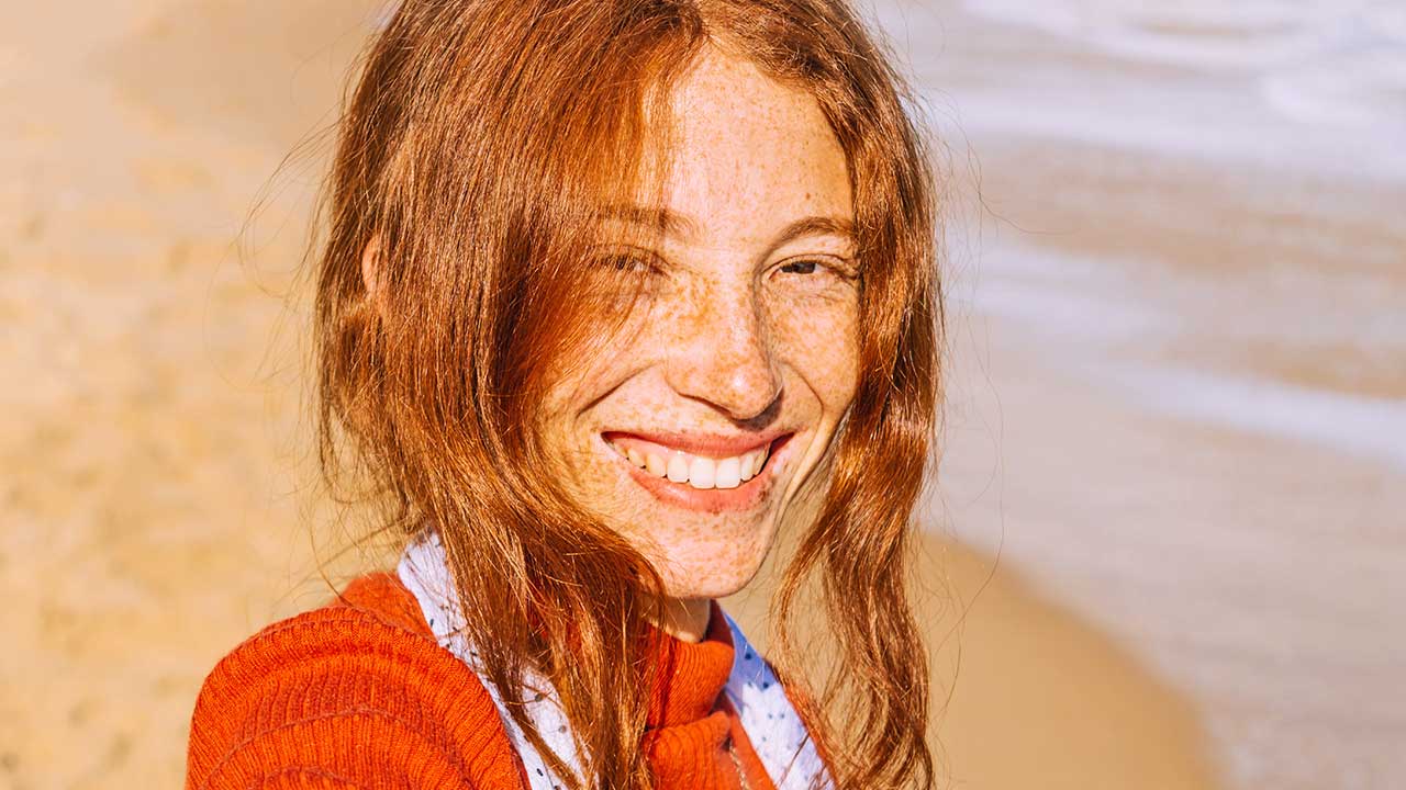 junge Frau mit Sommersprossen lächelt