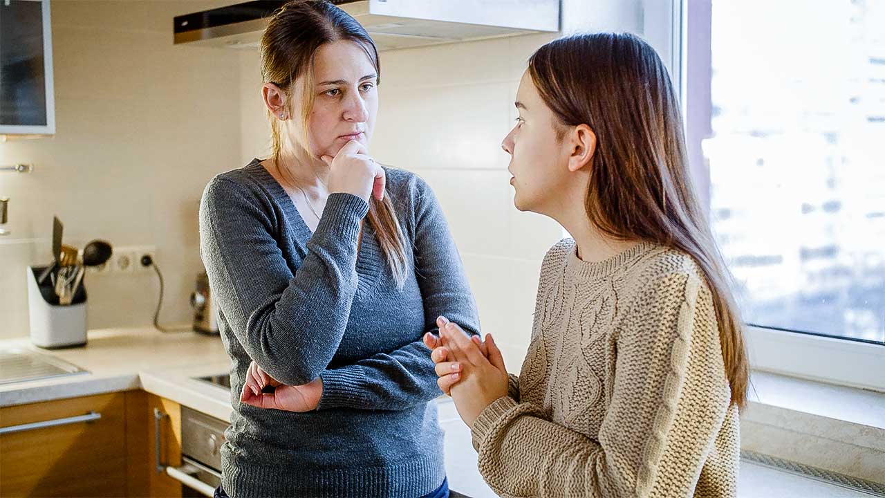 Mutter mit ihrer Teenager-Tochter in einem ernsten Gespräch