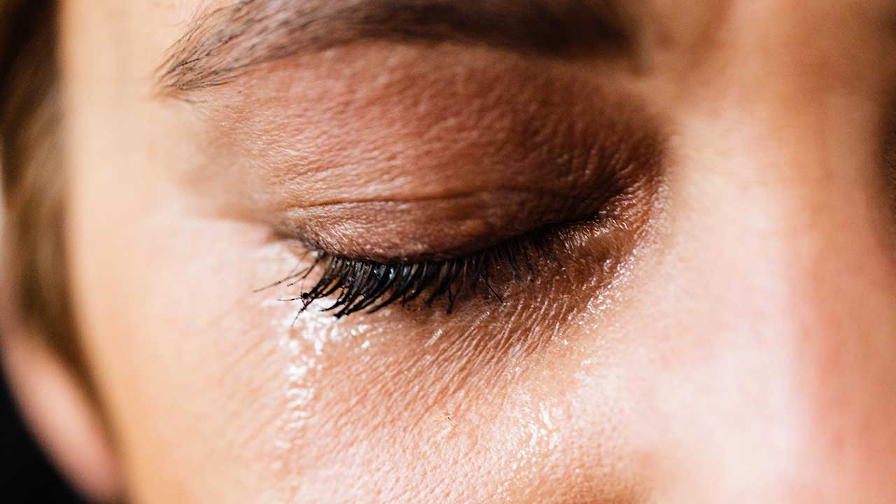 Grossaufnahme eines Frauenauges mit Tränenwasser