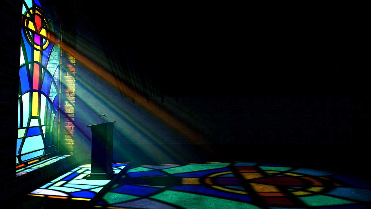 Licht fältt von einem Kirchenfenster auf eine Kanzel