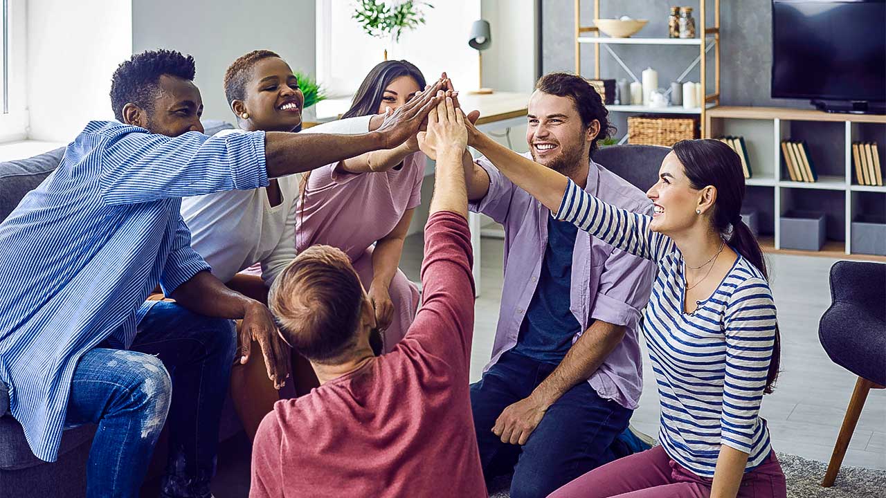 Gruppe von jungen Erwachsenen macht High Five