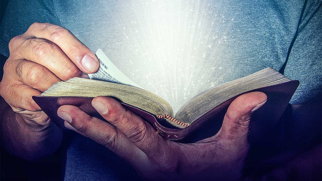 Hände haltende eine strahlende Bibel
