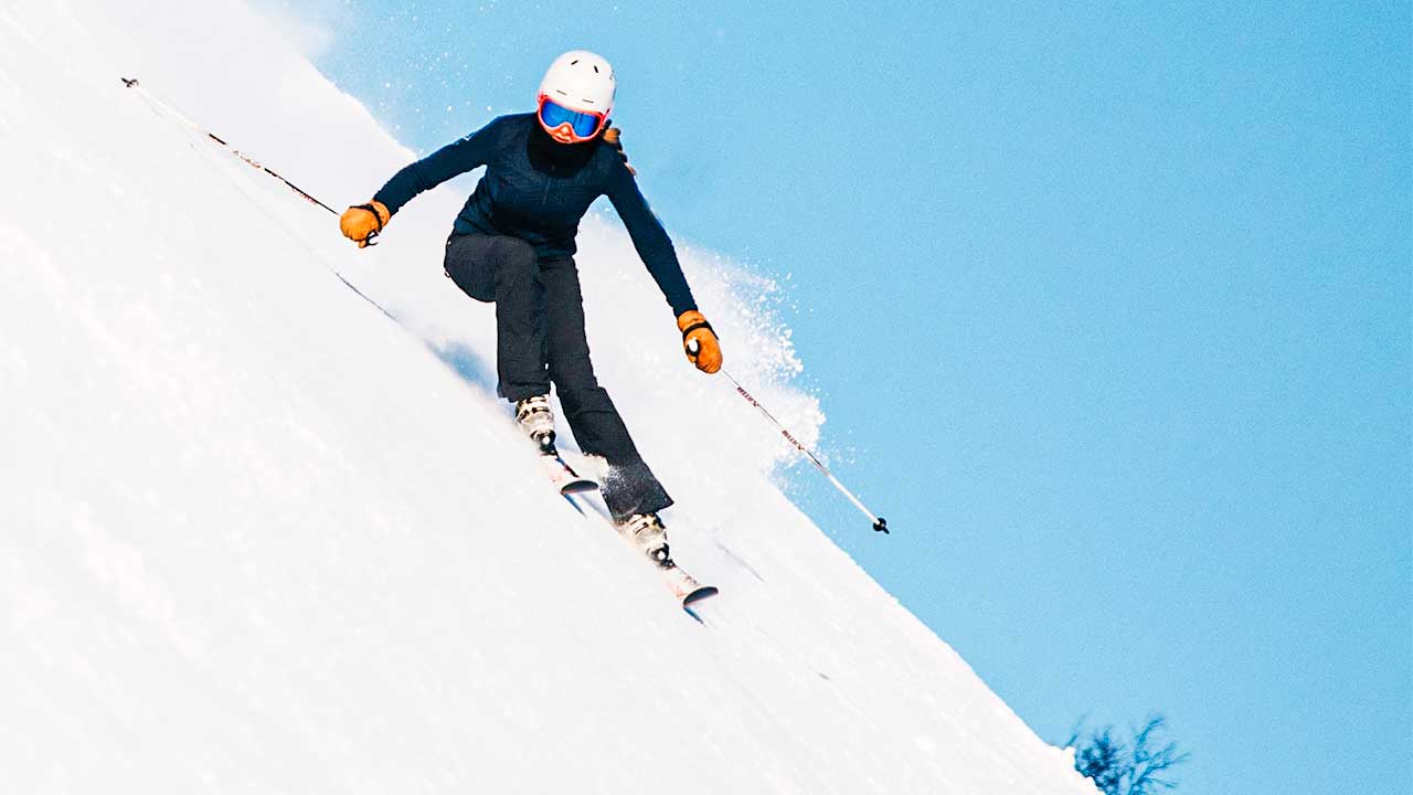 Skifahrerin fährt einen steilen Hang hinunter