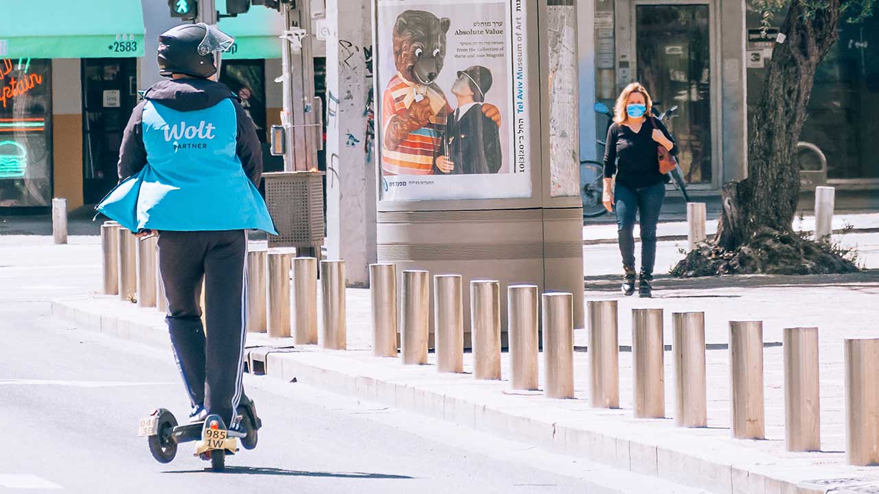 Fussgängerin und Rollerfahrer auf dem Rabin Square in Tel Aviv