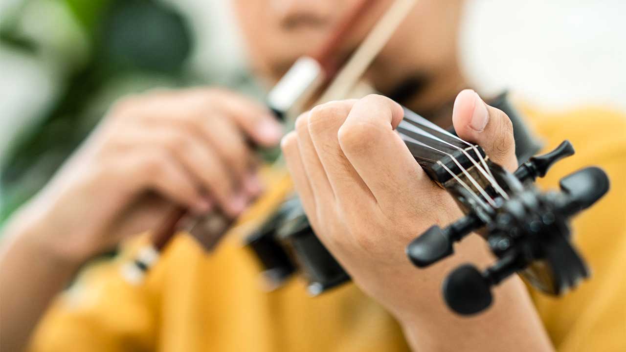 Hände eines Jungen mit einer Geige