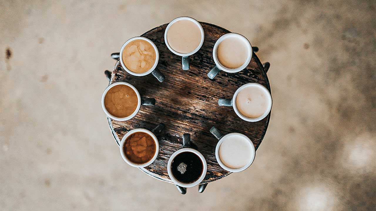 Verschiedene Kaffeetassen mit verschieden hellen Kaffees