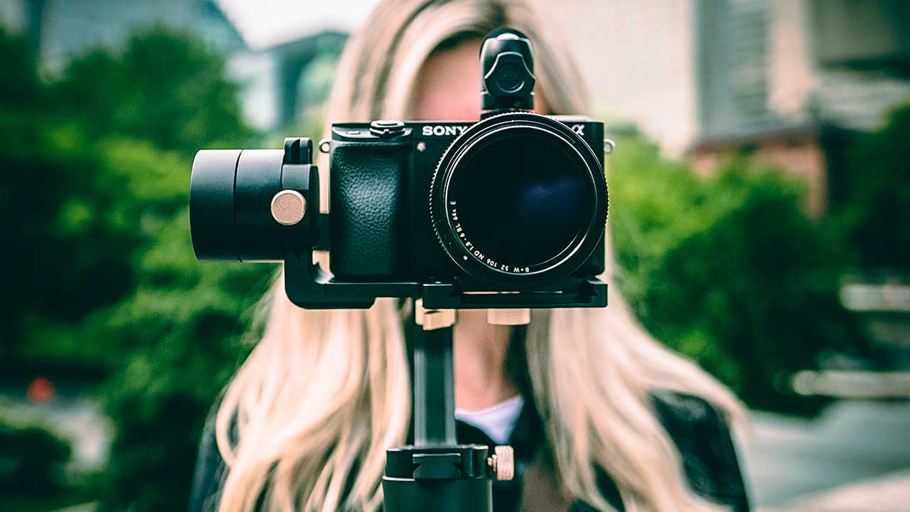 Frau mit Gesicht hinter einer Kamera
