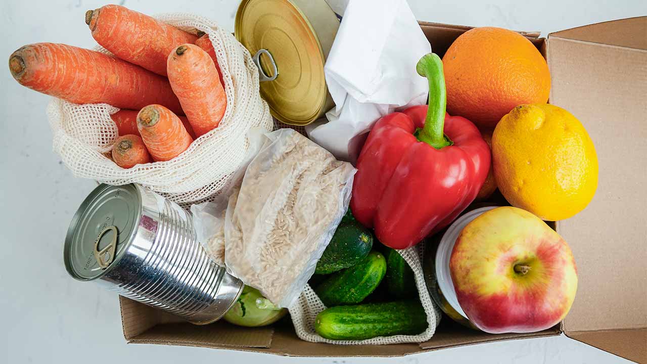 Früchte, Gemüse und Konserven in einem Karton