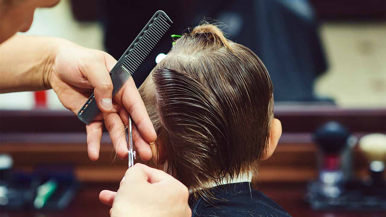 Junge beim Coiffeur lässt sich die Haare schneiden