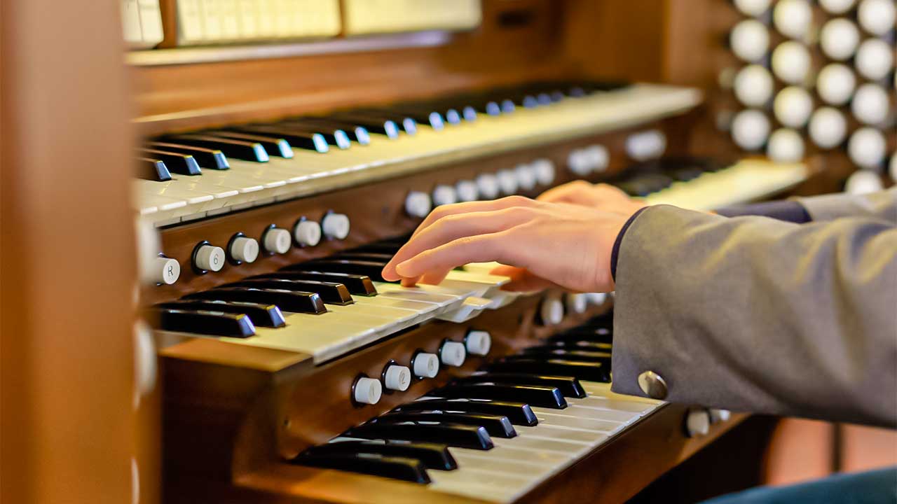 Männerhände spielen auf einer Kirchenorgel