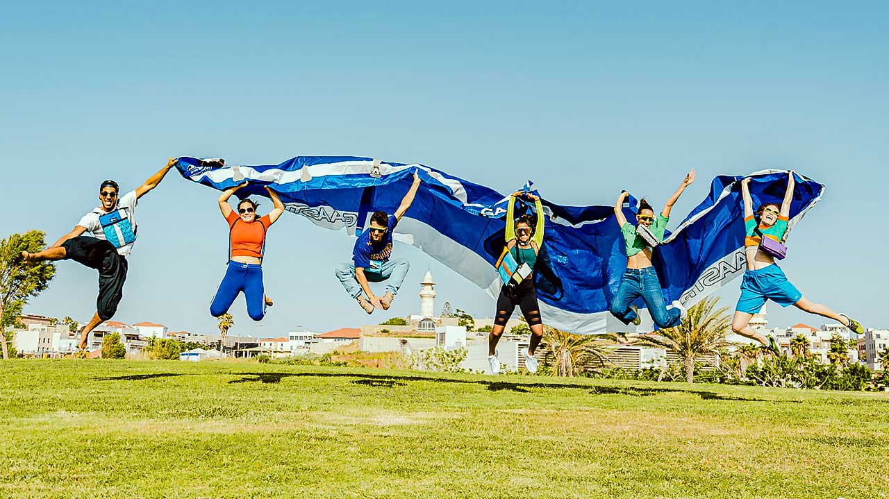 Junge Menschen springen mit einem Kitesurfing-Fallschirm hoch