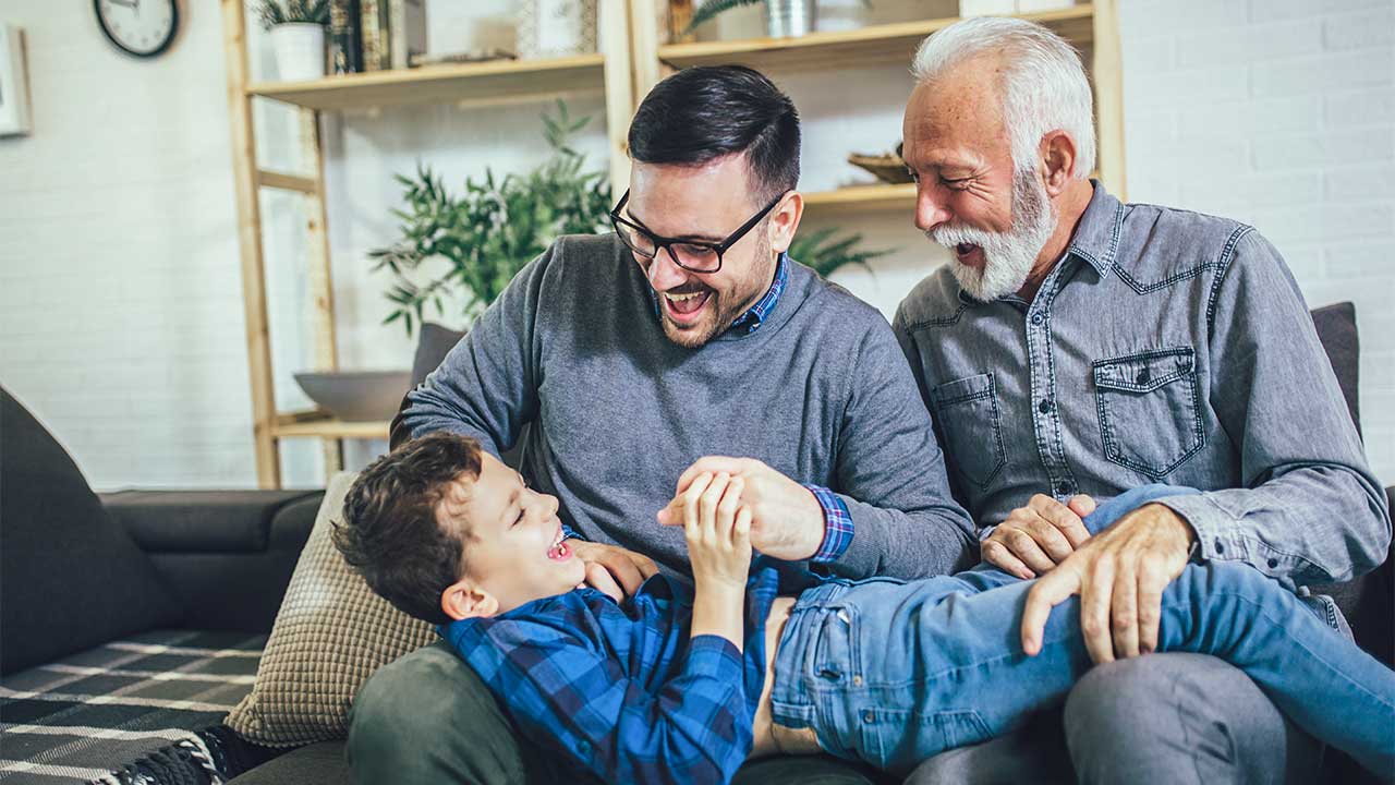 Drei Generationen von Männern auf dem Sofa