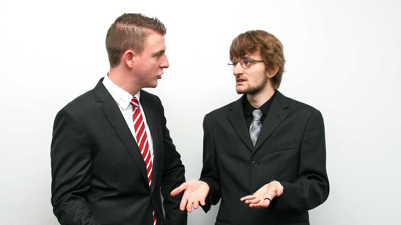 Zwei junge Männer in Anzügen in einer ernsten Diskussion