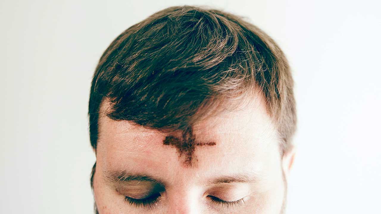 Aschenkreuz auf der Stirn eines Mannes