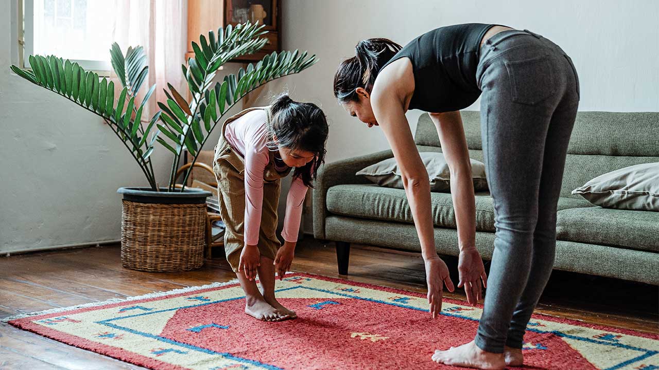 Mutter und Tochter machen Fitnessübungen in ihrer Wohnung