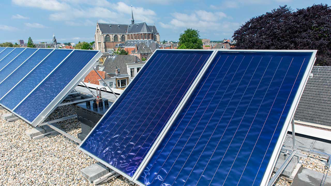 Sonnenkollektoren mit Kirchengebäude im Hintergrund in Leiden, Niederlande | (c) 123rf
