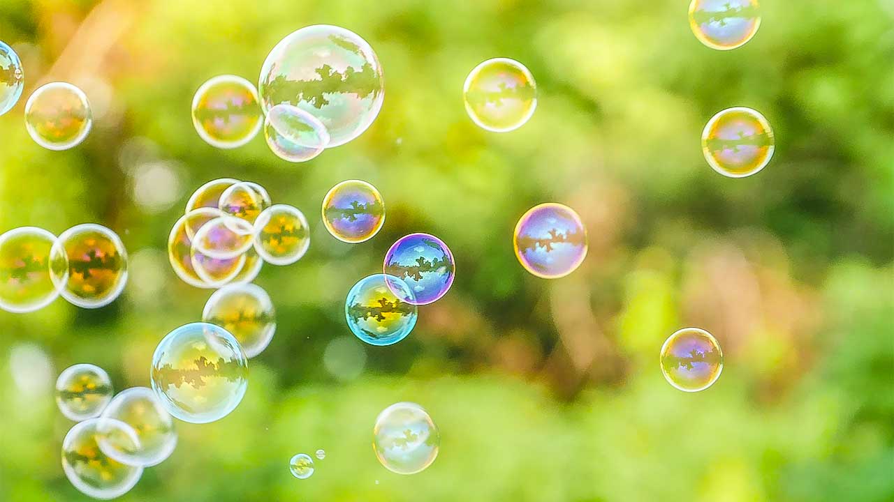 Seifenblasen vor einem grünen Natur-Hintergrund