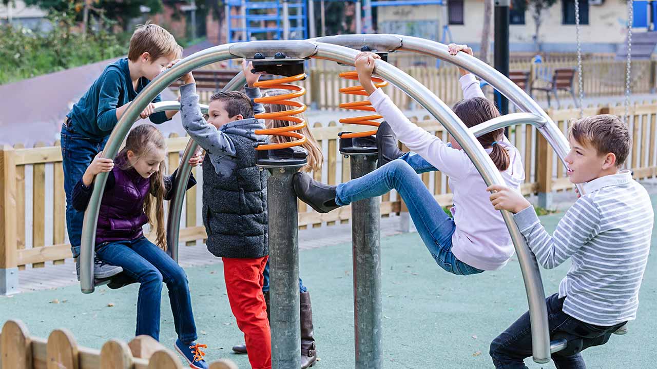 fünf Kinder im Primarschulalter spielen auf einem Spielplatz