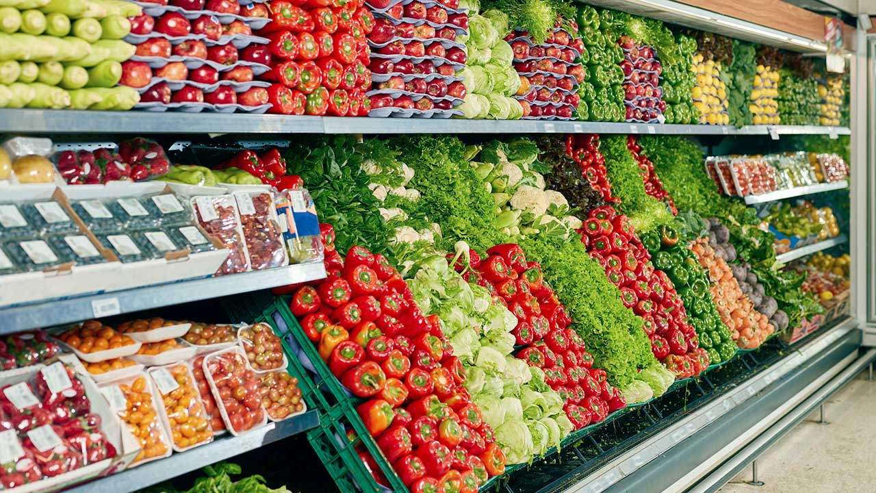 Gefüllte Regale mit Gemüse und Salat in einem Supermarkt