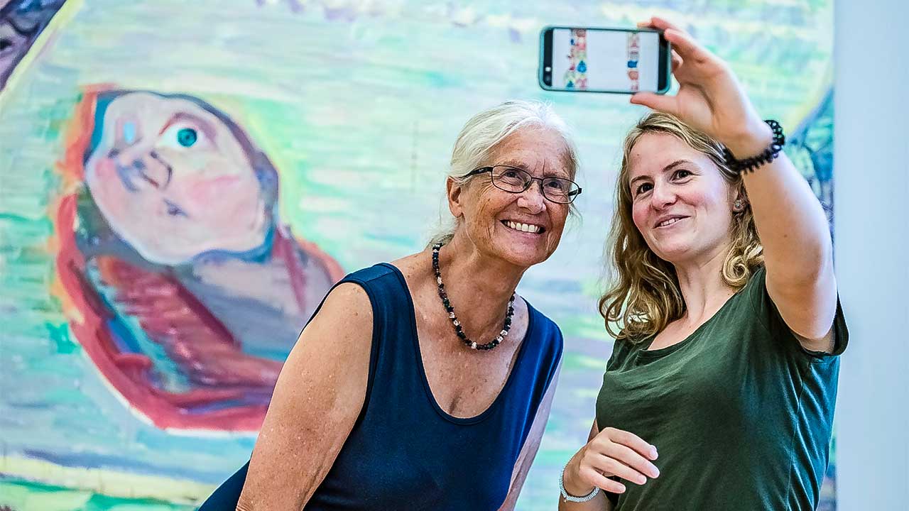 Tandem im Museum: ein Frauen-Duo macht vor einem Gemälde ein Selfie von sich