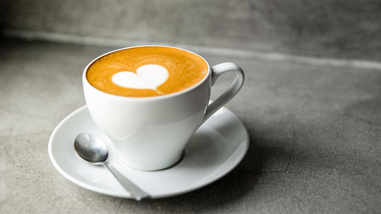 Tasse Kaffee, deren Schaum ein Herz zeigt
