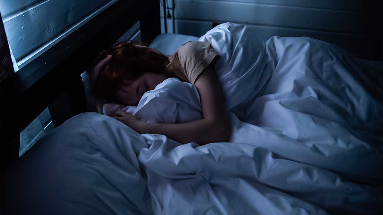 Frau schläft in einem dunklen Zimmer