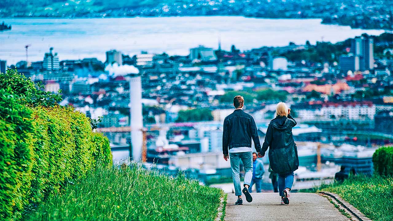 Paar spaziert in Höngg, mit Blick auf das Zentrum von Zürich und den See